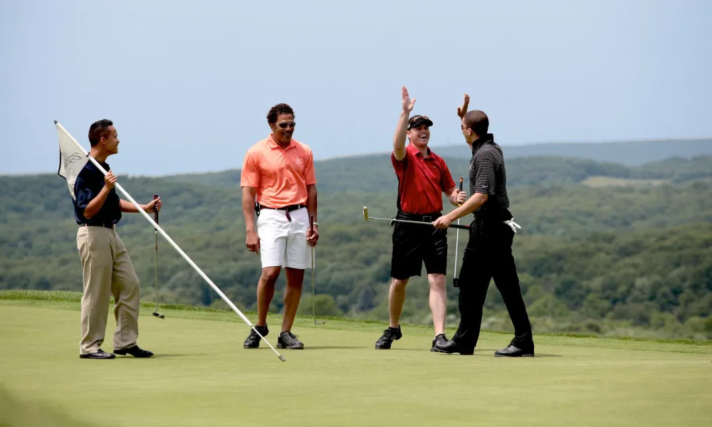 Four golfers on the putting green