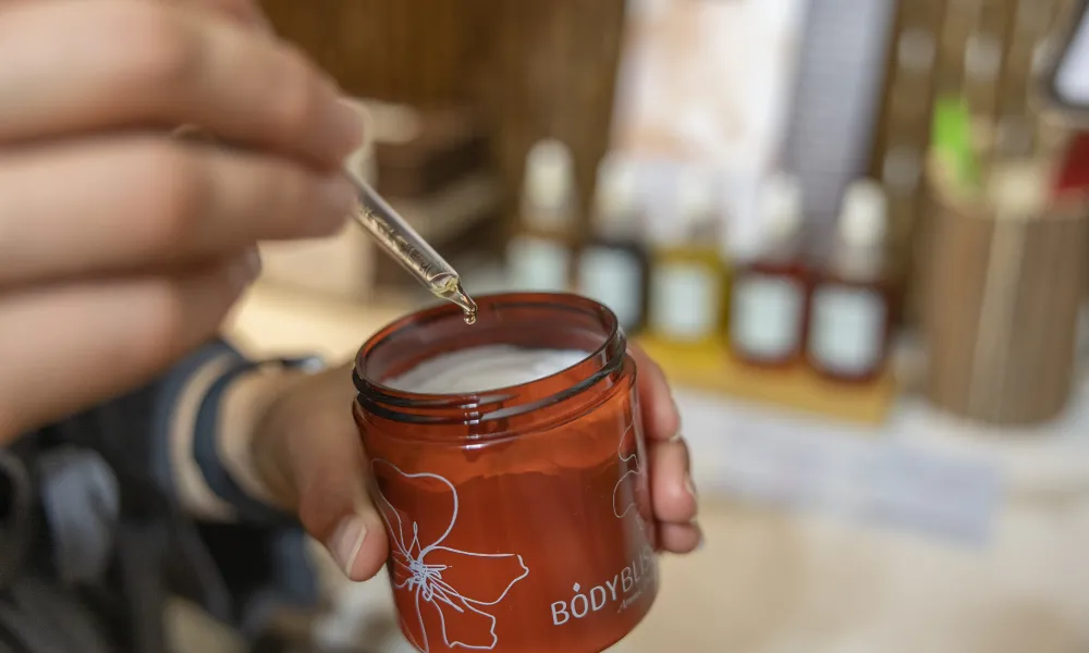 Dropper of essential oil being put in body butter