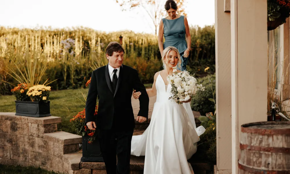 Bride holds man's arm during her ceremony at Ballyowen wedding garden. 