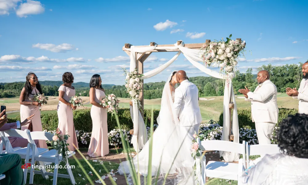 Bride and groom kiss during their wedding ceremony at Ballyowen Wedding Garden