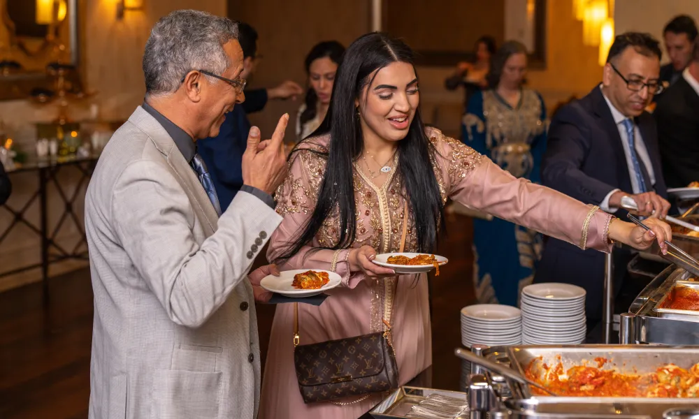 Guests getting food during cocktail hour at wedding. 