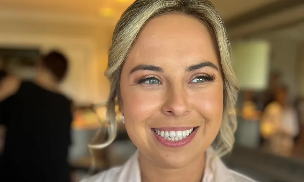 Woman smiling wearing white pajamas. 