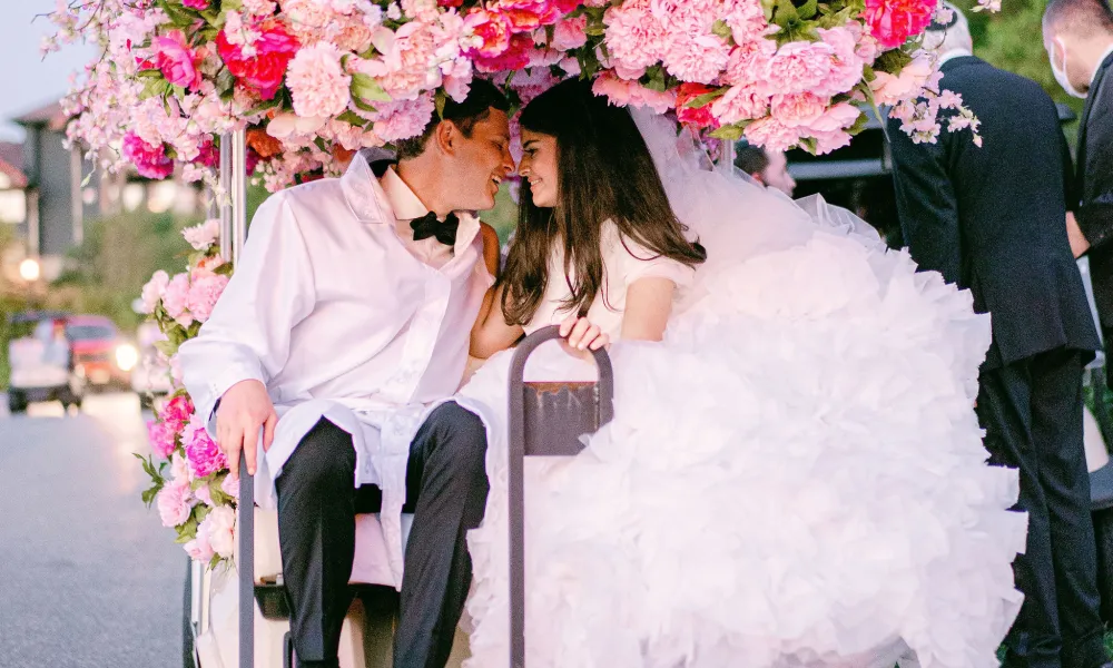 Bride and groom on golf cart during their exit from wedding reception at Big Sky Pavillion.