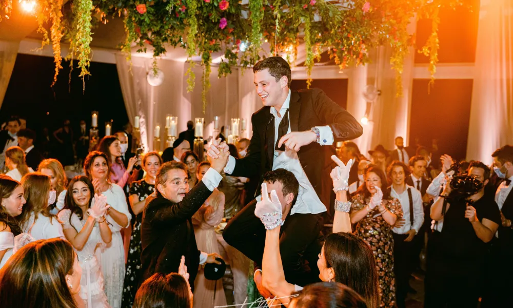 Groom being lifted in air during wedding reception at Big Sky Pavillion.