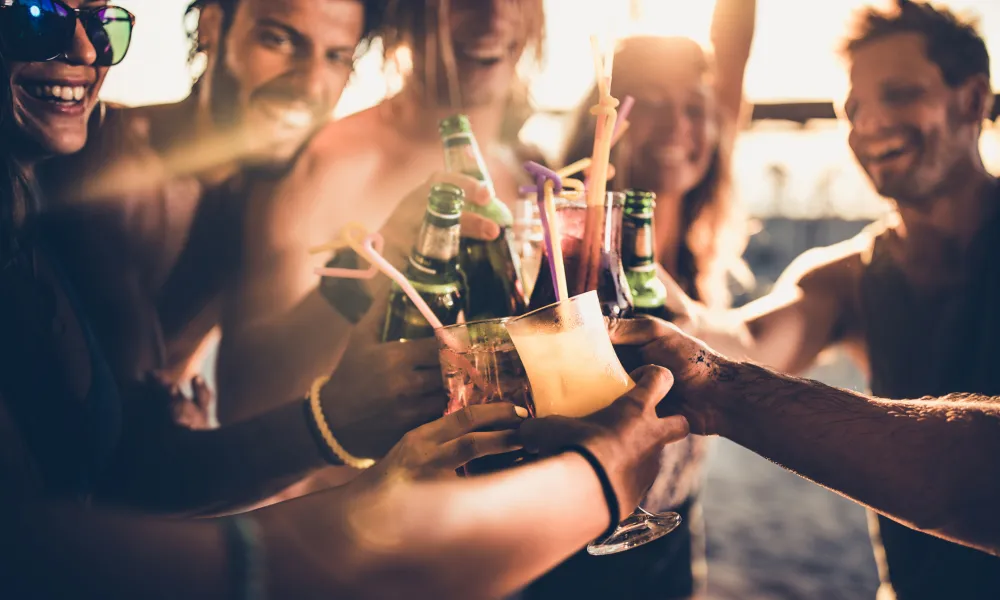 Friends clicking their glasses together in a cheers. 