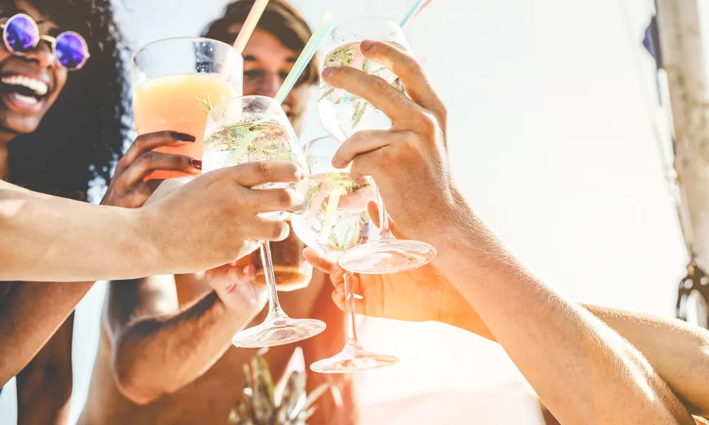 Friends clicking their glasses together in a cheers. 