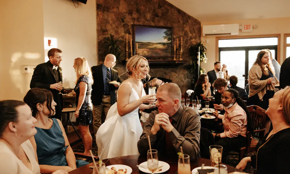 Bride holding drink during cocktail hour.