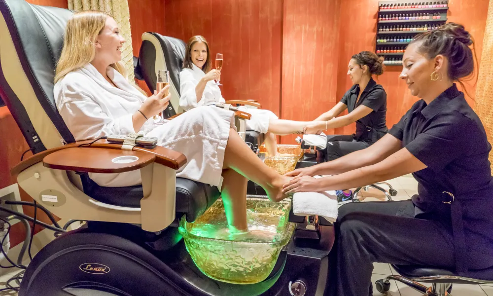 Two guests in white robes getting a pedicure at Reflections Spa.