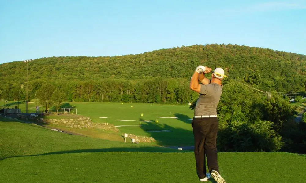 Golfer practicing at the driving range at Black Bear Golf Course