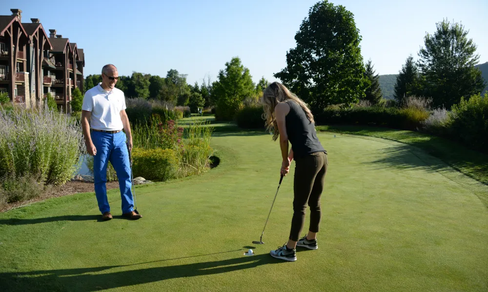 A couple enjoying a weekend getaway and golfing on the putting course at Crystal Springs Resort