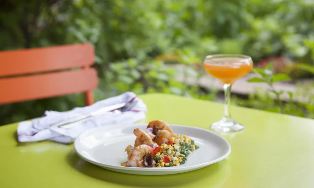 Food paired with orange colored cocktail in Chef's Garden.