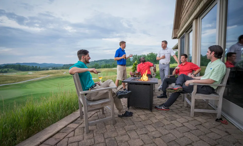 Guys sitting around a fire pit at a golf resort near NYC