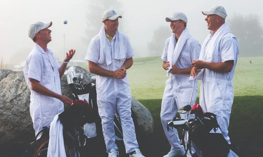 Four caddy's wearing white