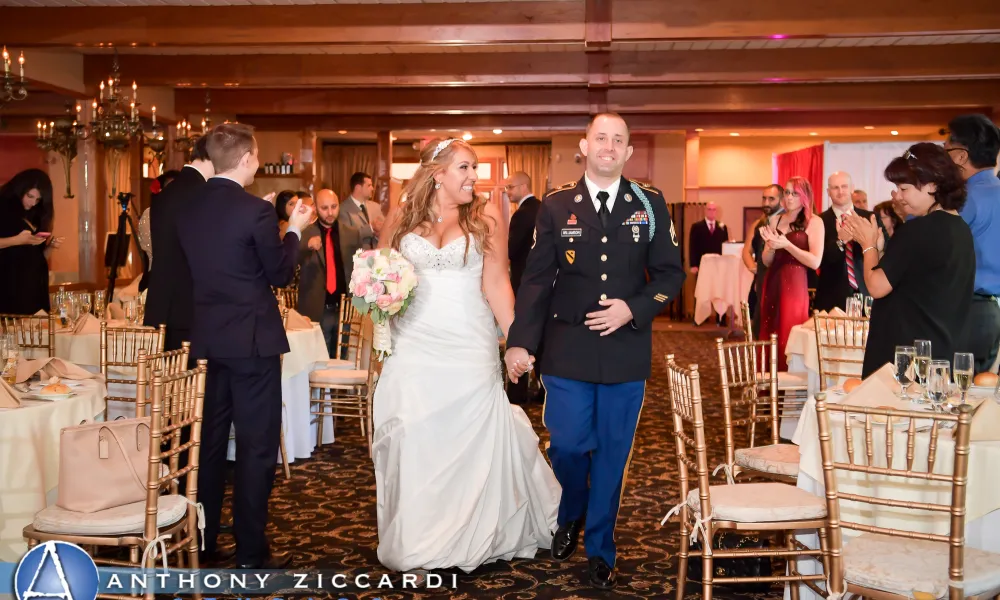 Military wedding couple holding hands walking into wedding reception