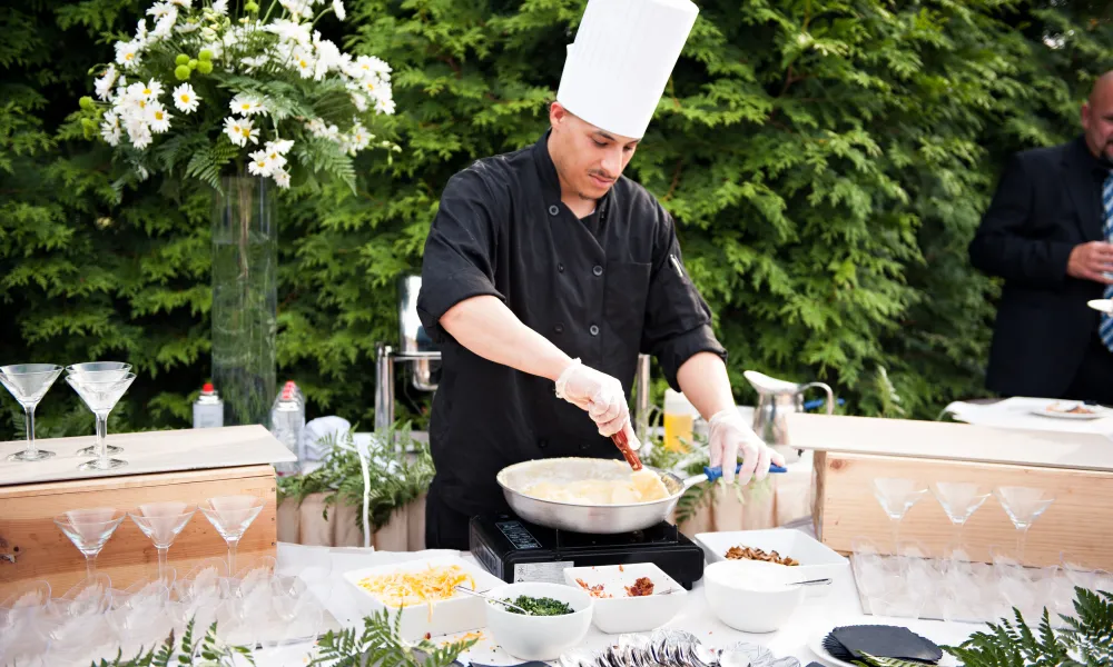 Chef cooking fresh food at cocktail hour