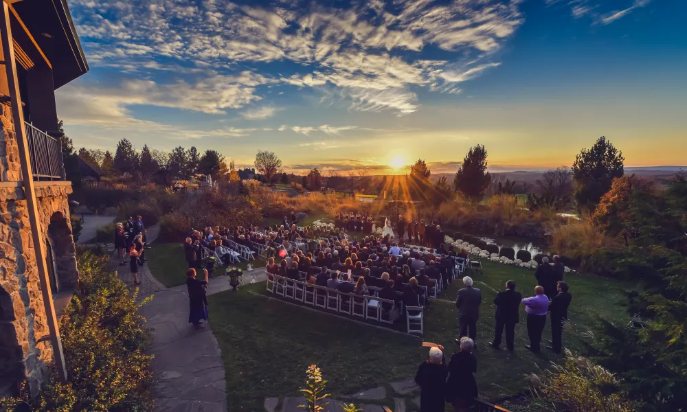 Sun setting on outdoor wedding ceremony at Grand Cascades Lodge.