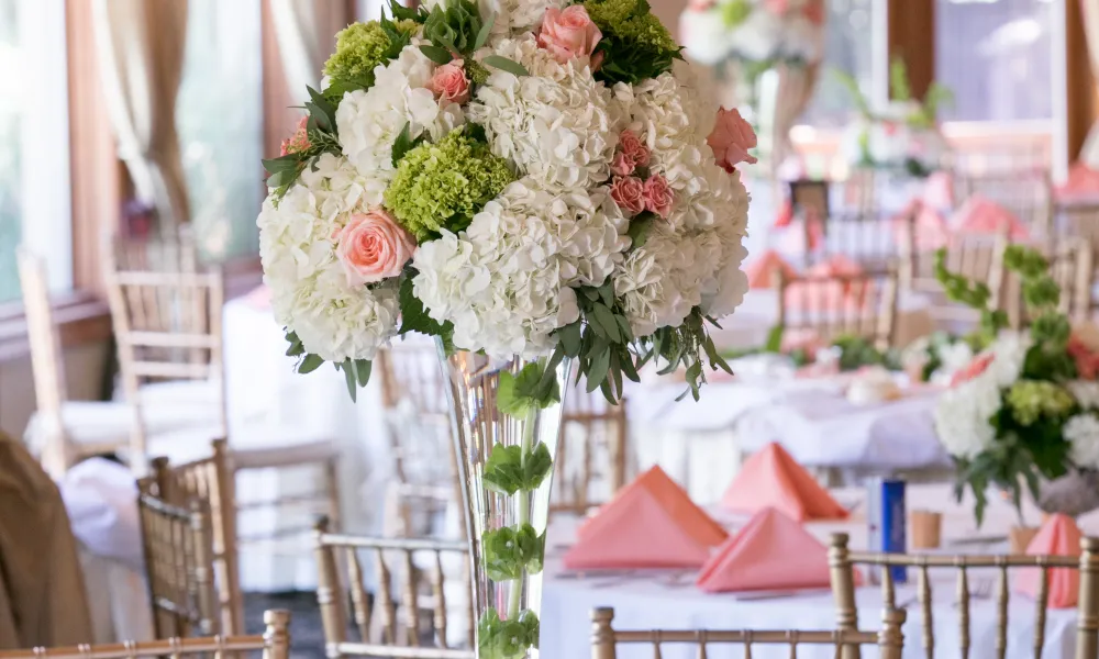 Wedding tables decorated with pink napkins and flowers.