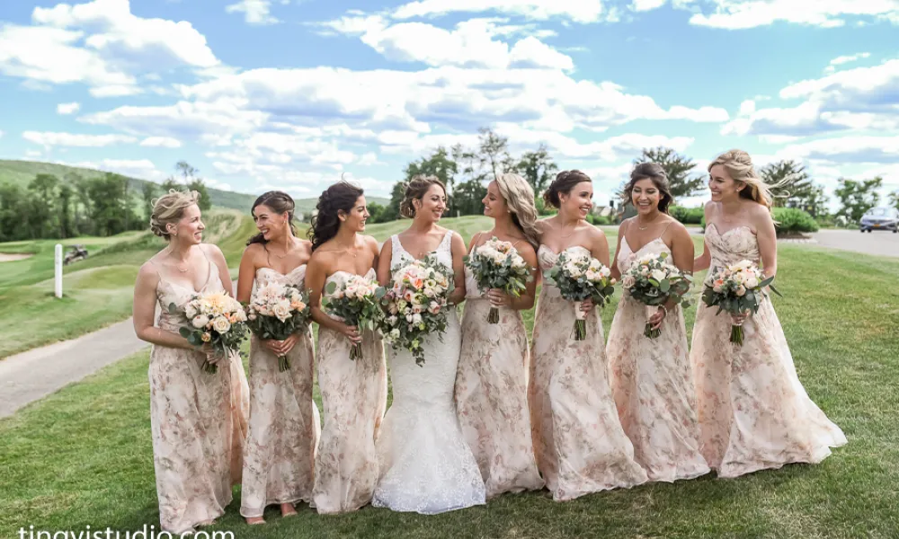 Bride standing with her bridesmaids who are wearing light pink dresses.