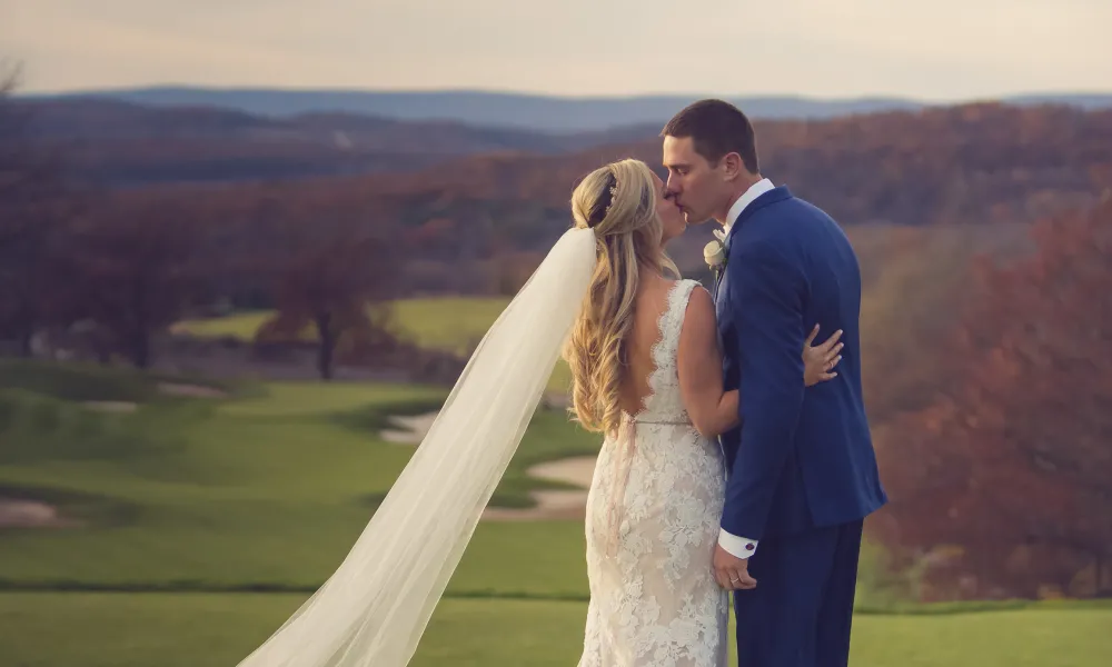 Bride and groom kissing on golf course at Crystal Springs Resort