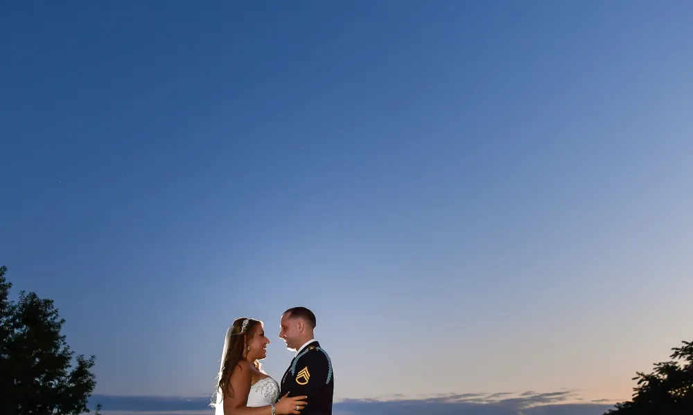 Military groom and bride in the spotlight at night