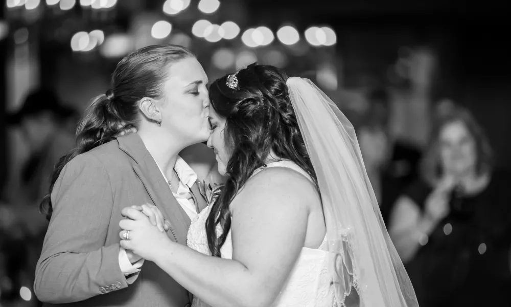 Bride kissing bride on forehead