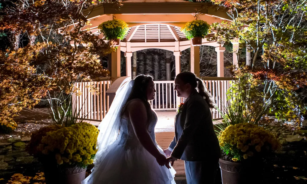 Brides in front of lit up Black Bear gazebo at night