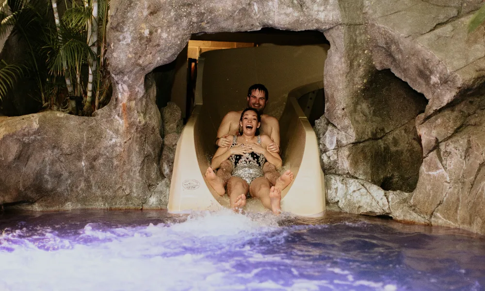 Bride and groom going down waterslide at Biosphere