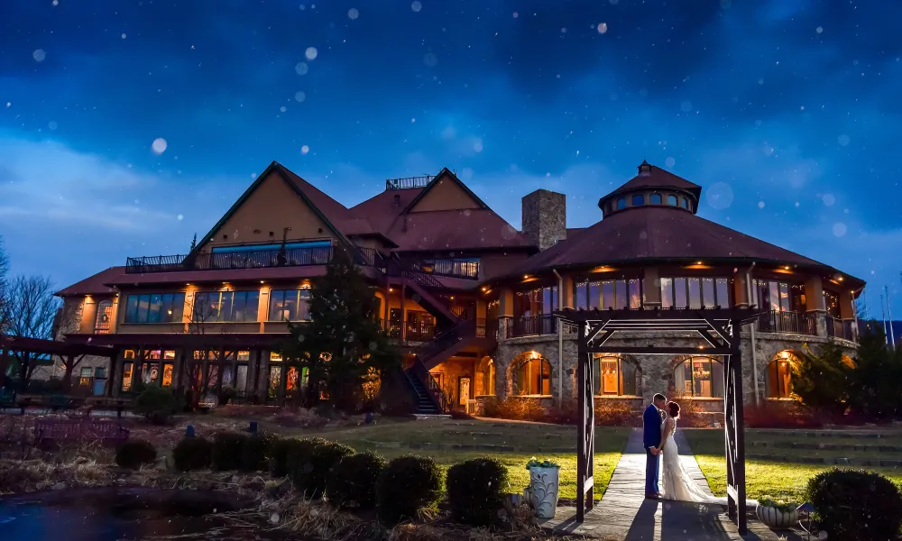 Bride and groom stand outside Crystal Springs Clubhouse at night.