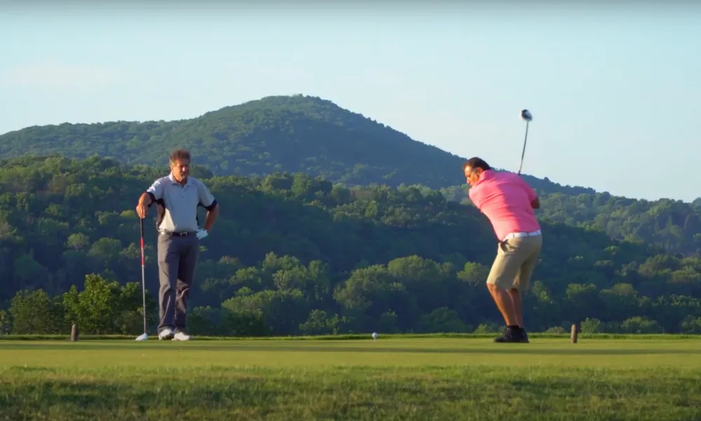 Two Golfers making their swings at a golf course near NYC