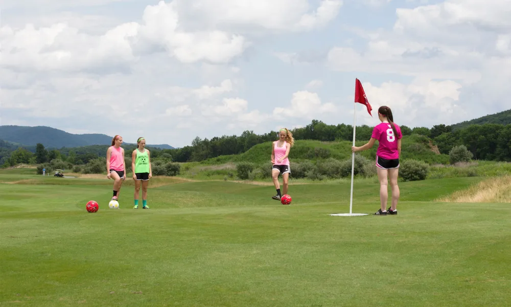 Four girls on a golf course at a resort near NYC playing foot golf