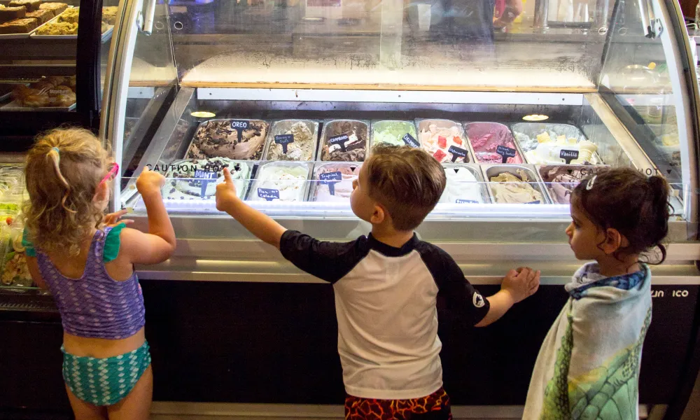 Three children standing in front of the gelato counter in the Biosphere cafe.