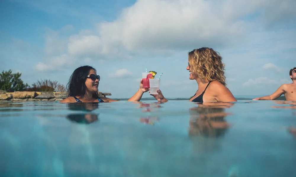 Girlfriends drinking cocktails by the pool at a resort close to NYC