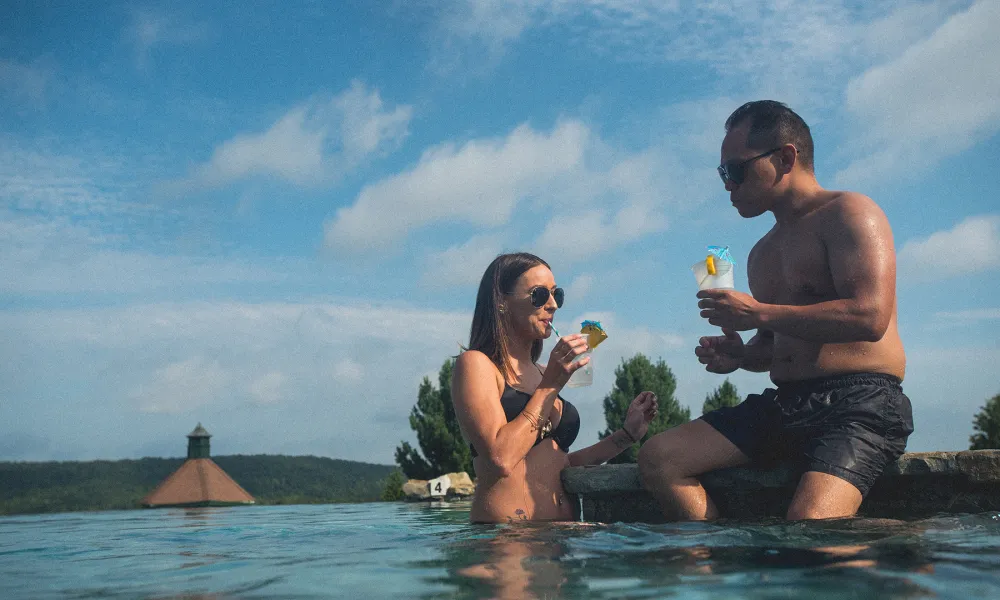 Couple enjoying cocktails at a resort outdoor pool