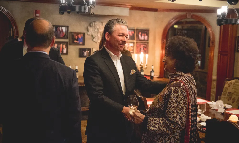 Man and woman shaking hands in the wine cellar.