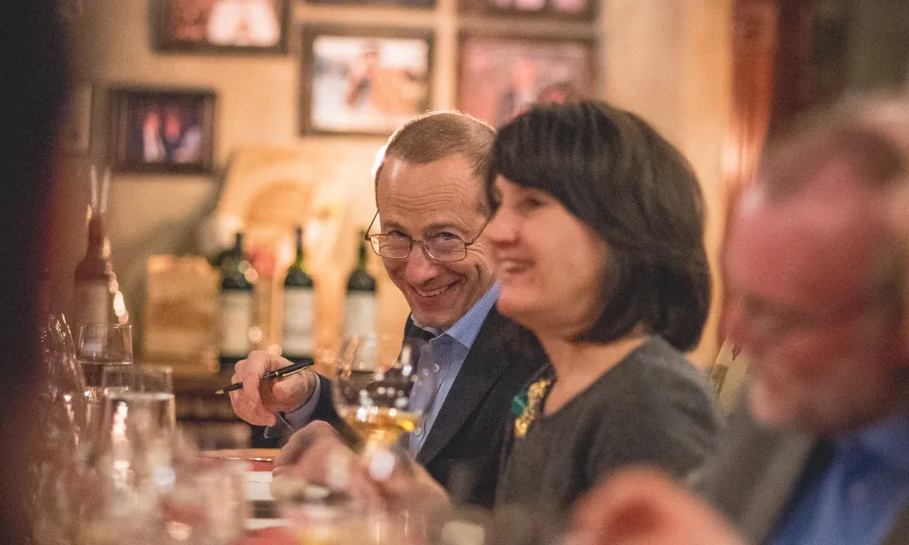 Man and woman laughing during wine cellar dinner.