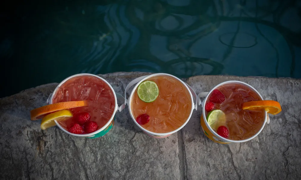 Aerial view of three rum buckets with fresh fruit.