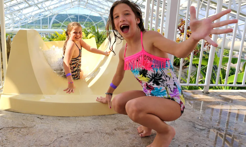 Two children on top of Biosphere pool complex indoor slide