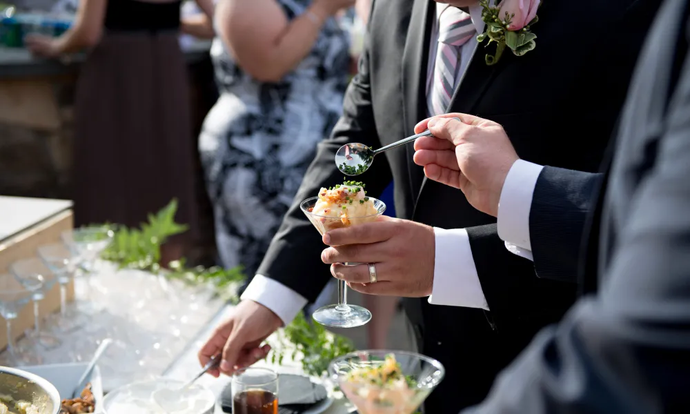 Men serving food at wedding cocktail hour