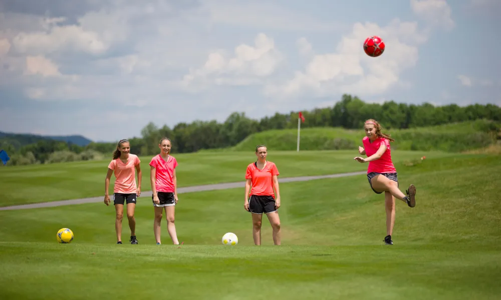 Young girls playing foot golf on a golf course at Crystal Springs Resort