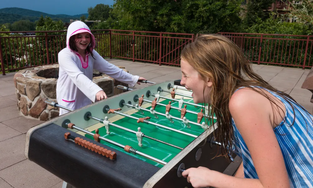 Two children playing foosball.