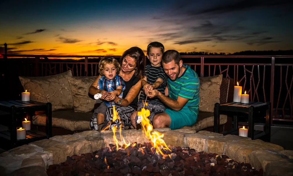 Family roasting marshmallows on the Fire and Water Terrace at Grand Cascades Lodge.