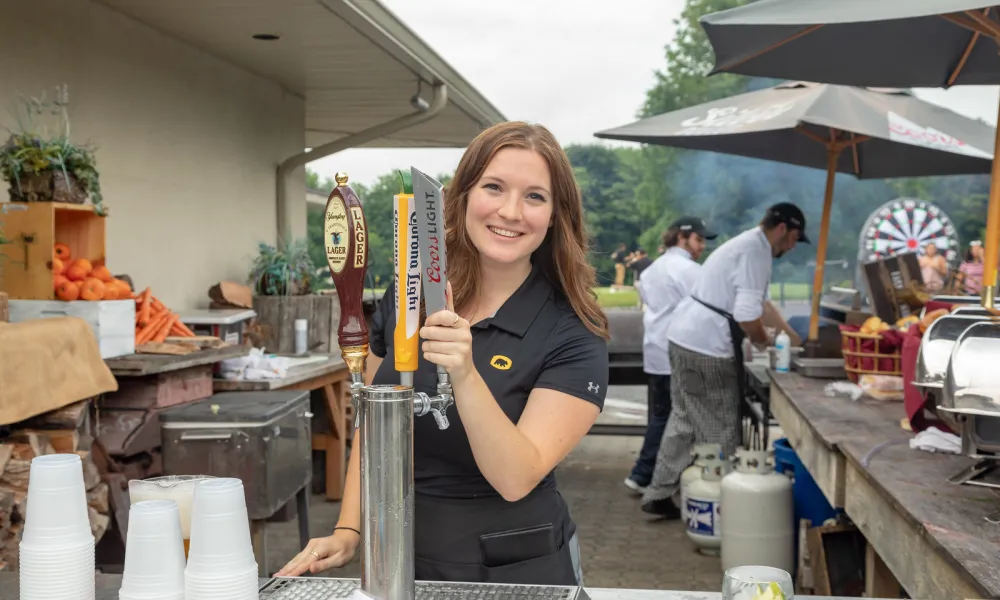 Server at Black Bear Golf Club serving beer