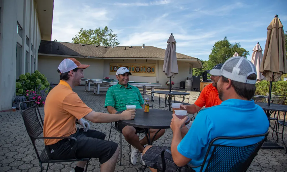 Four guys sitting outside on the patio at the Bear Den Grill