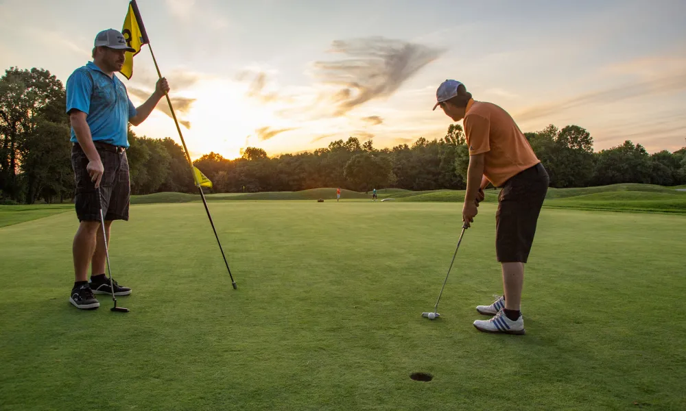 Two men on the putting green of a hole at Black Bear Golf course