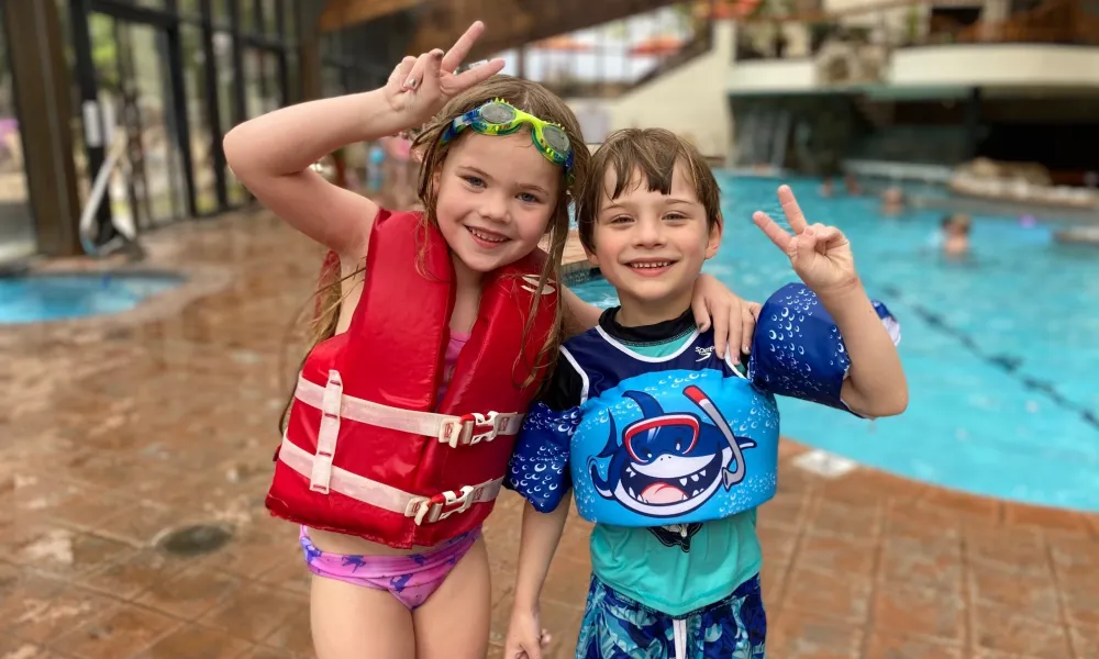 Young children holding up peace signs at Minerals indoor pools