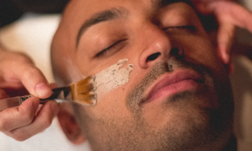 Mask being applied to man's face during facial