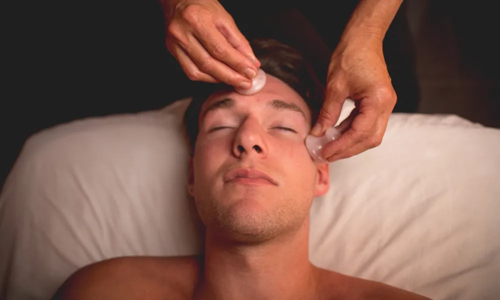 Male receiving rose quartz facial