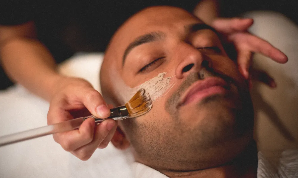 Mask being applied to man's face during facial