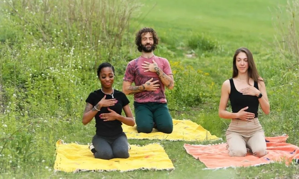 Group of three people meditating in a field  in New Jersey. 