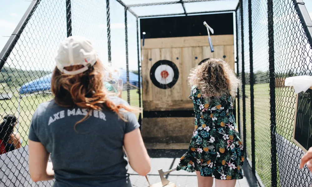 Woman throwing axe at target.